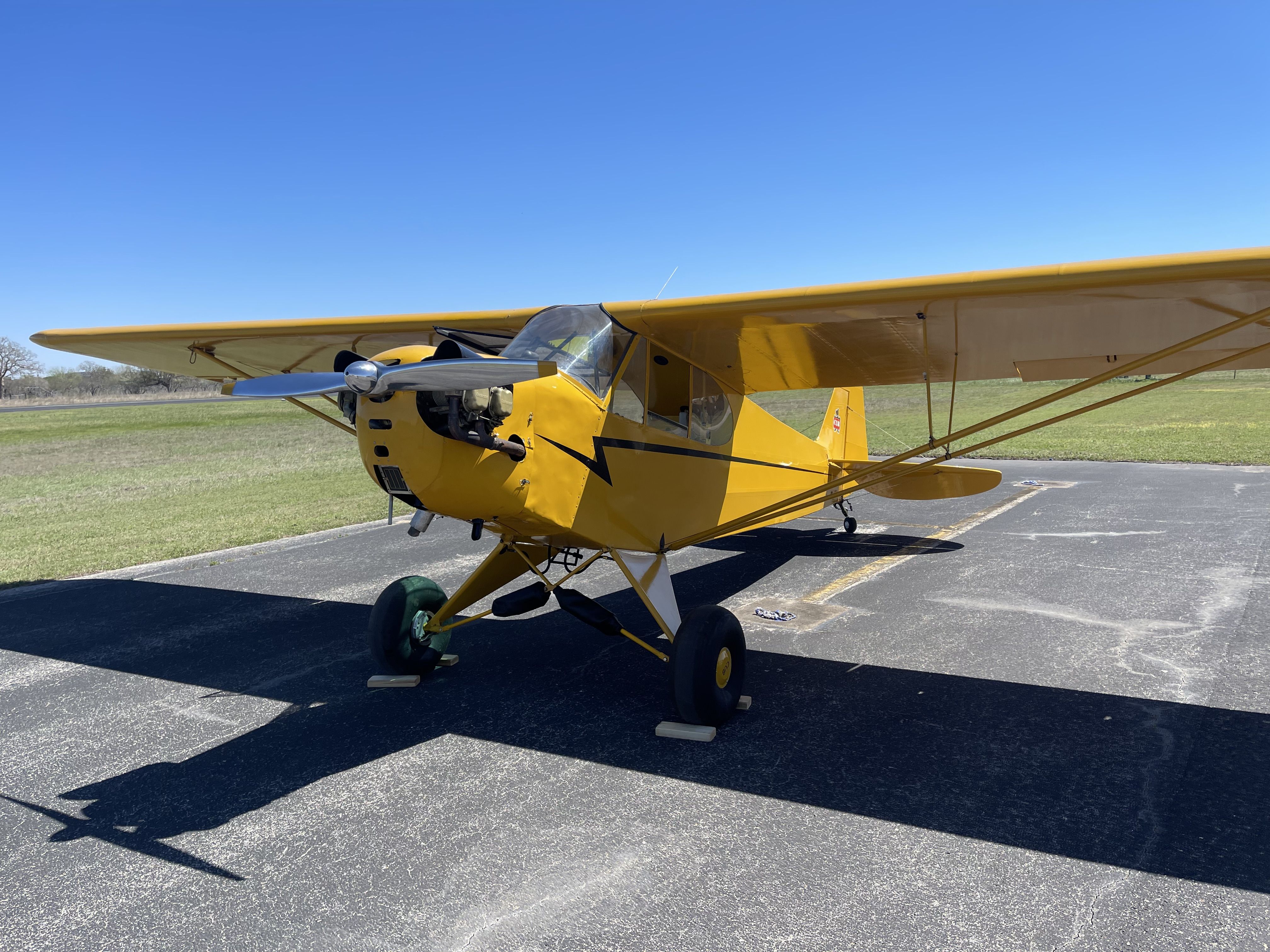 woman and young man sitting in cockpit of the piper cub